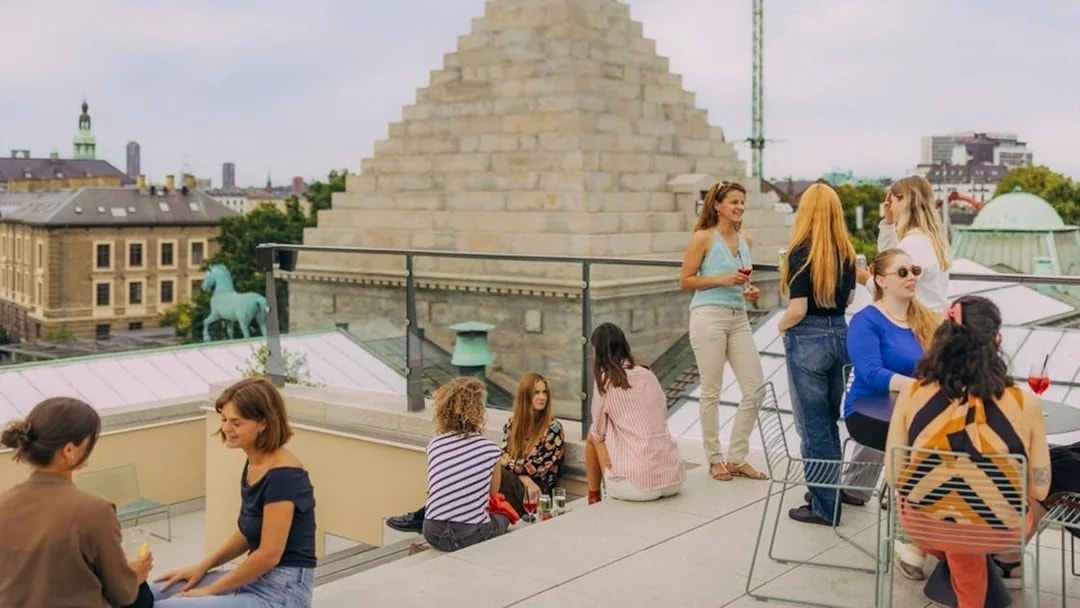 Group enjoying rooftop view in Copenhagen with historic architecture in the background.