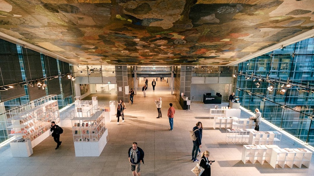 Interior of the Black Diamond library in Copenhagen with visitors exploring exhibits.
