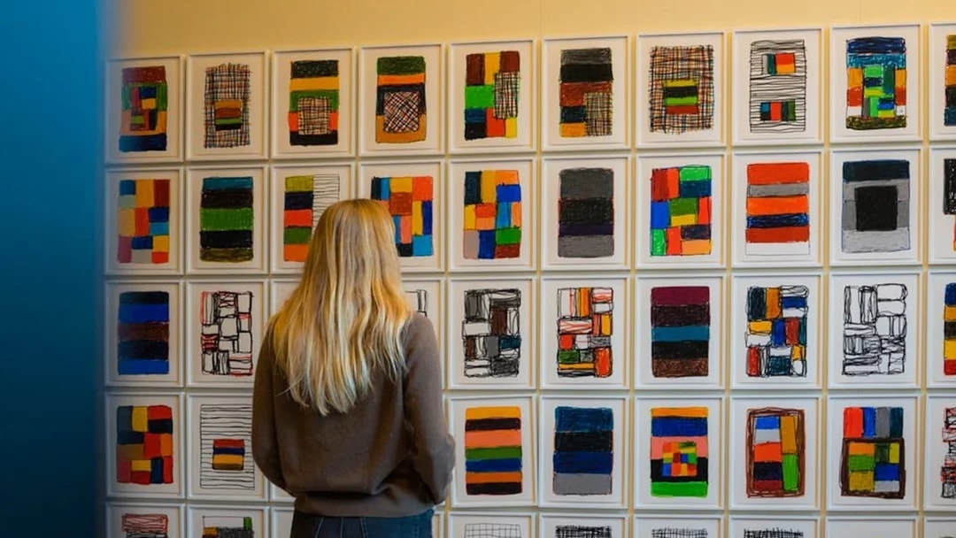 Person viewing colorful abstract art in a Copenhagen gallery.