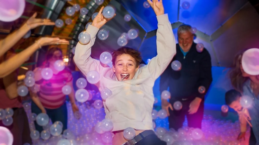 Person enjoying a ball pit experience in Copenhagen attraction.