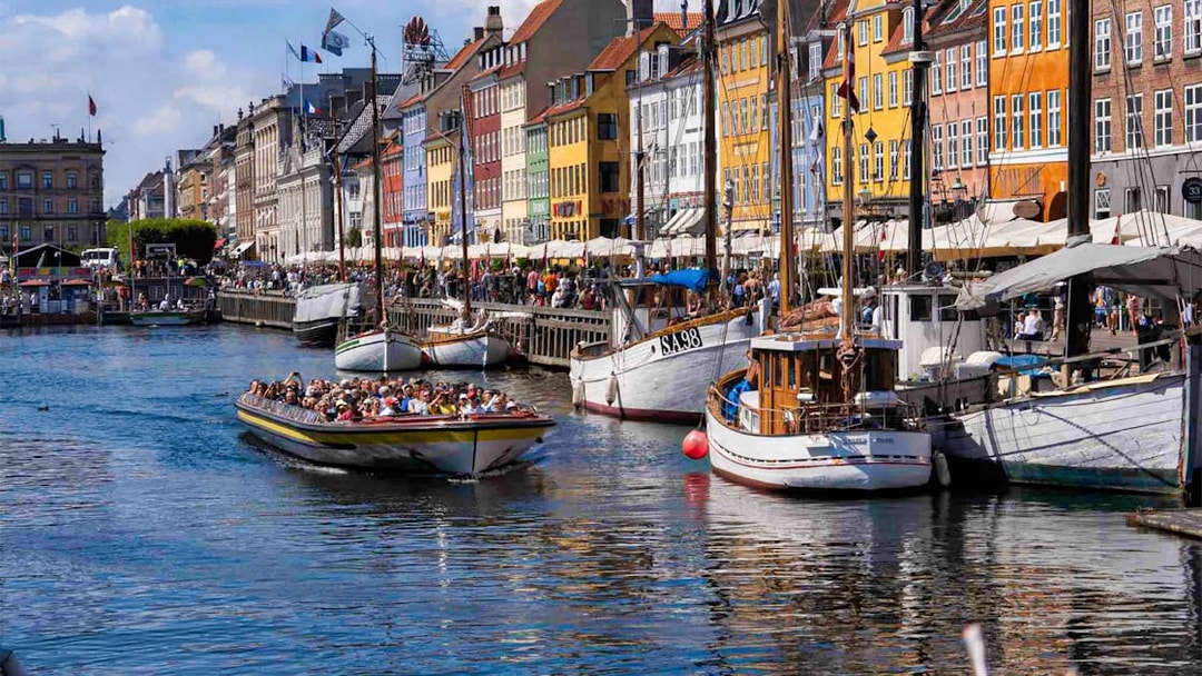 Boat tour passing colorful buildings along Nyhavn canal, Copenhagen.
