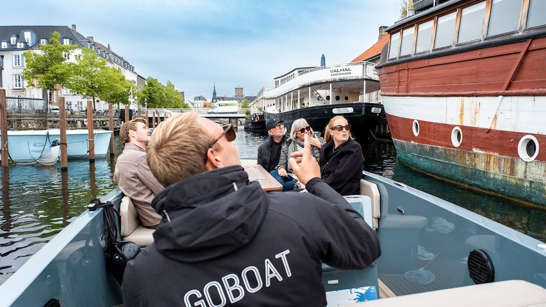 Guests on an electric boat tour in Copenhagen, viewing the city while the captain pedals.