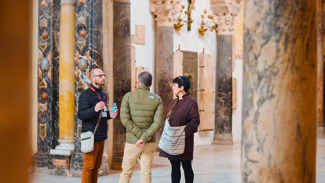 Guide explaining history to tourists inside Córdoba Mosque.
