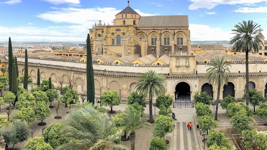 Córdoba Cathedral-Mosque entrance with courtyard and palm trees.