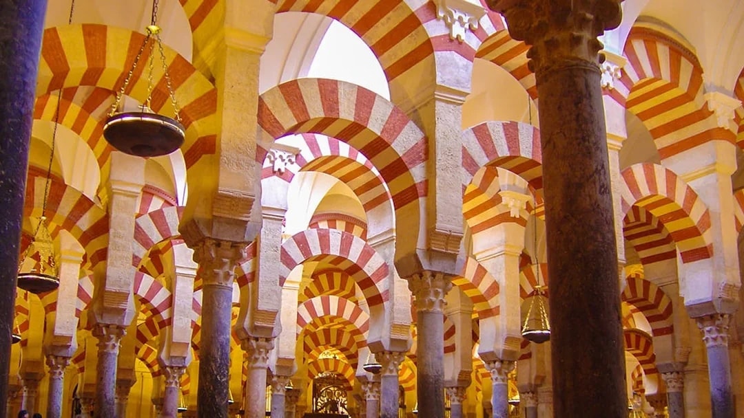 Striped arches inside the Mosque-Cathedral of Córdoba on a day trip from Granada.
