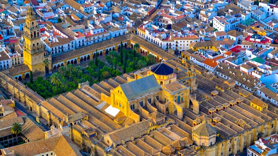 Aerial view of the Mosque-Cathedral of Córdoba, Spain, surrounded by city buildings.