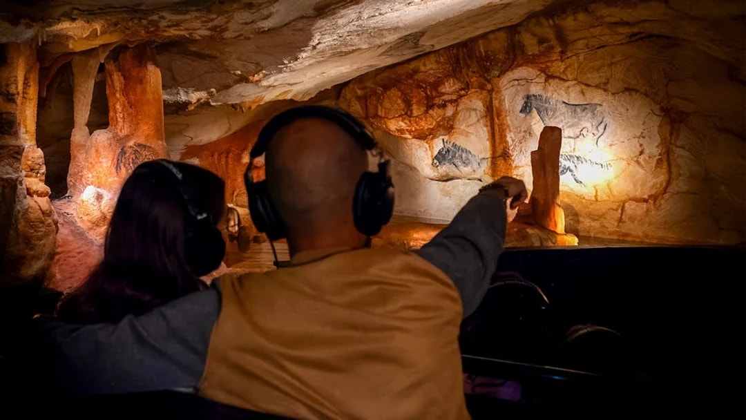 Visitors with headphones view prehistoric cave paintings in Cosquer Cave, Marseille.