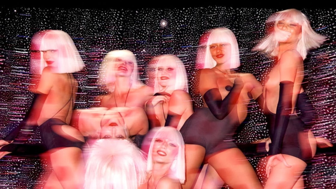 Performers at Crazy Horse show in Paris with vibrant lighting effects.