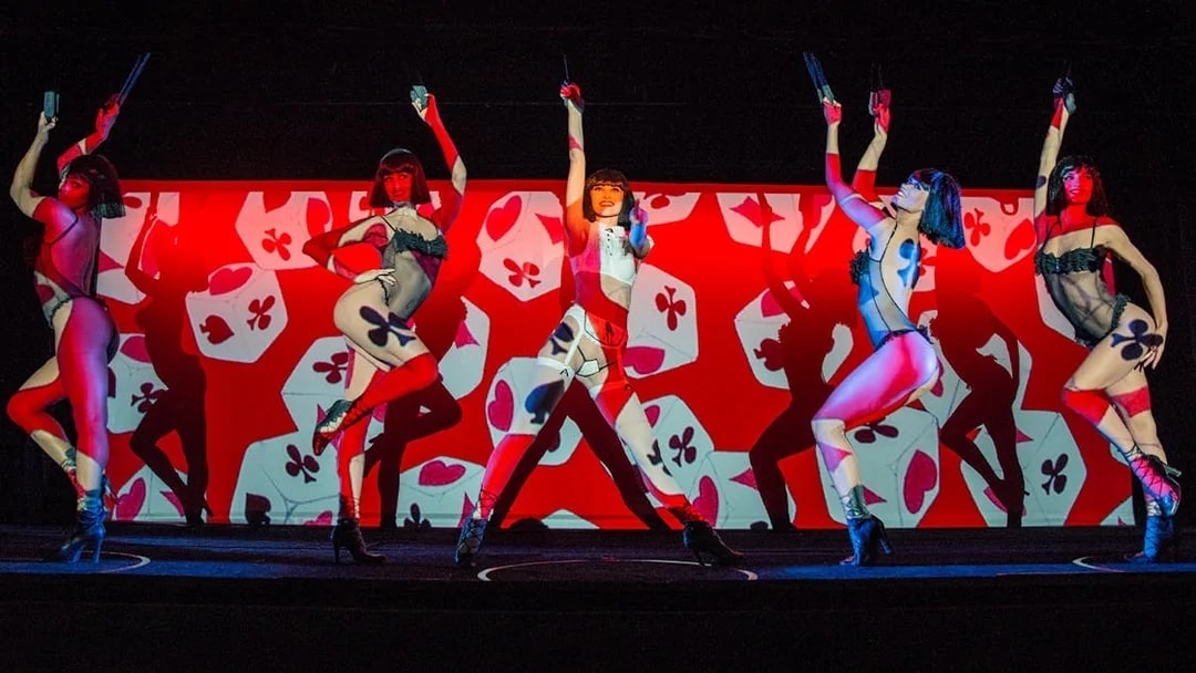 Performers on stage at Crazy Horse Cabaret Show with vibrant red and black backdrop.