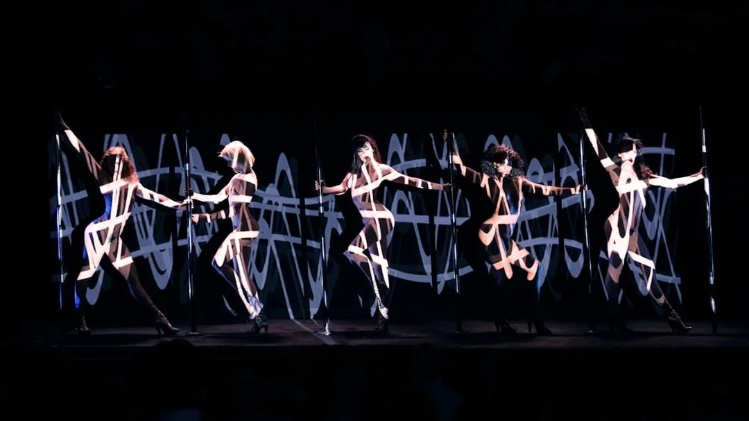 Performers on stage at Crazy Horse Cabaret Show with dynamic lighting effects.