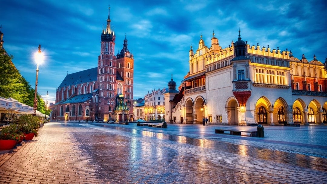 Krakow's Main Square at dusk with St. Mary's Basilica and Cloth Hall.
