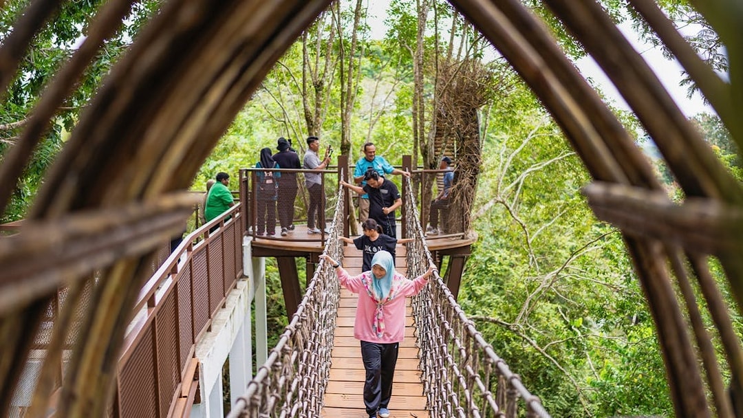 Visitors crossing a canopy bridge at Crocodile Adventureland Langkawi.
