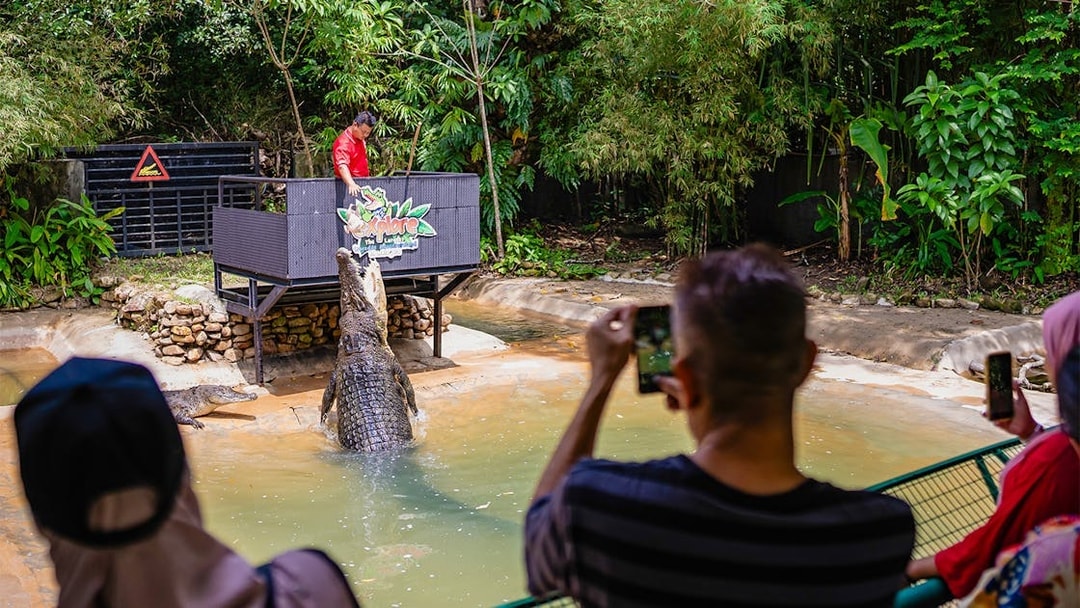 Crocodile feeding show at Crocodile Adventureland Langkawi with visitors watching.