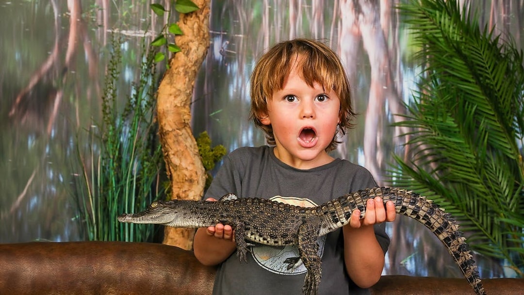 Child holding a baby crocodile at Crocosaurus Cove, Darwin.
