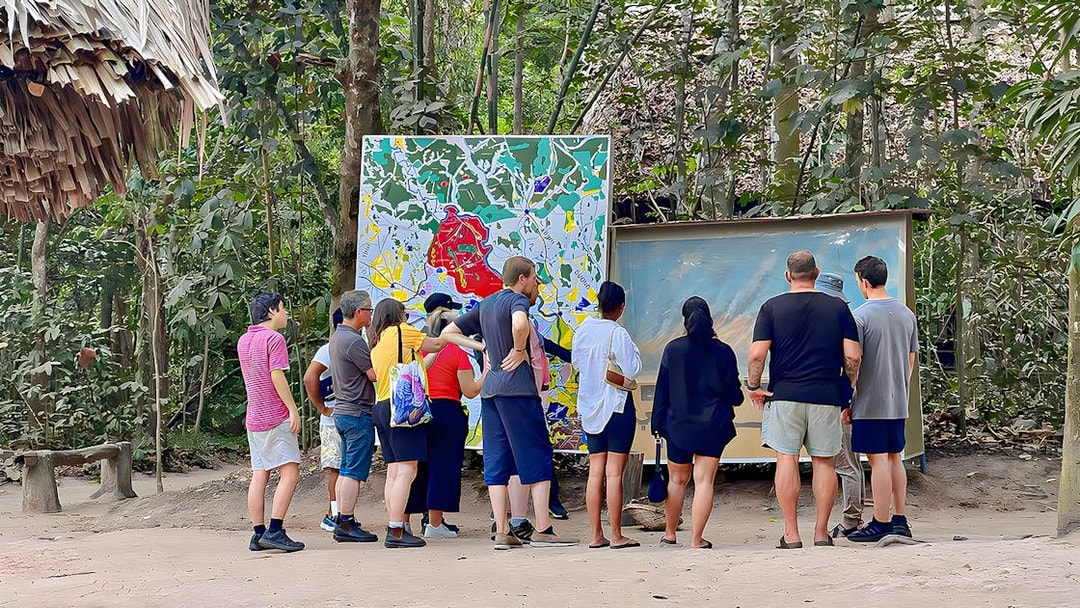 Tour group examining maps at Cu Chi Tunnels, Vietnam.
