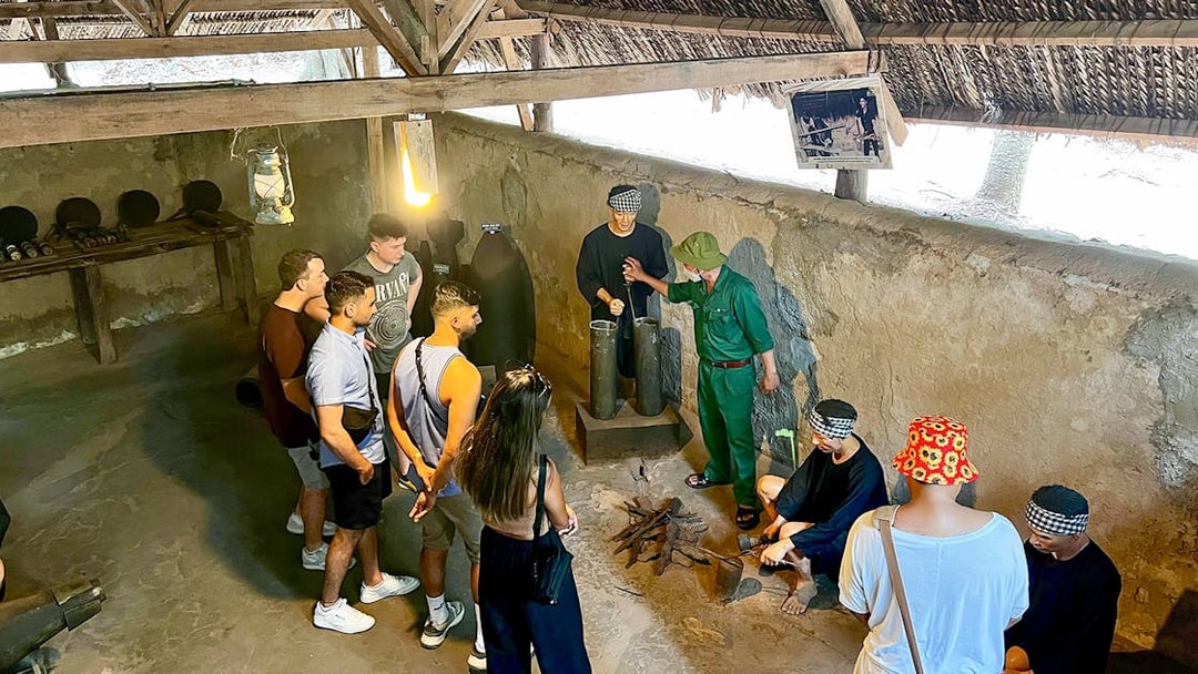 Tour group with guide learning about kitchen works during war at Cu Chi Tunnel, Vietnam.
