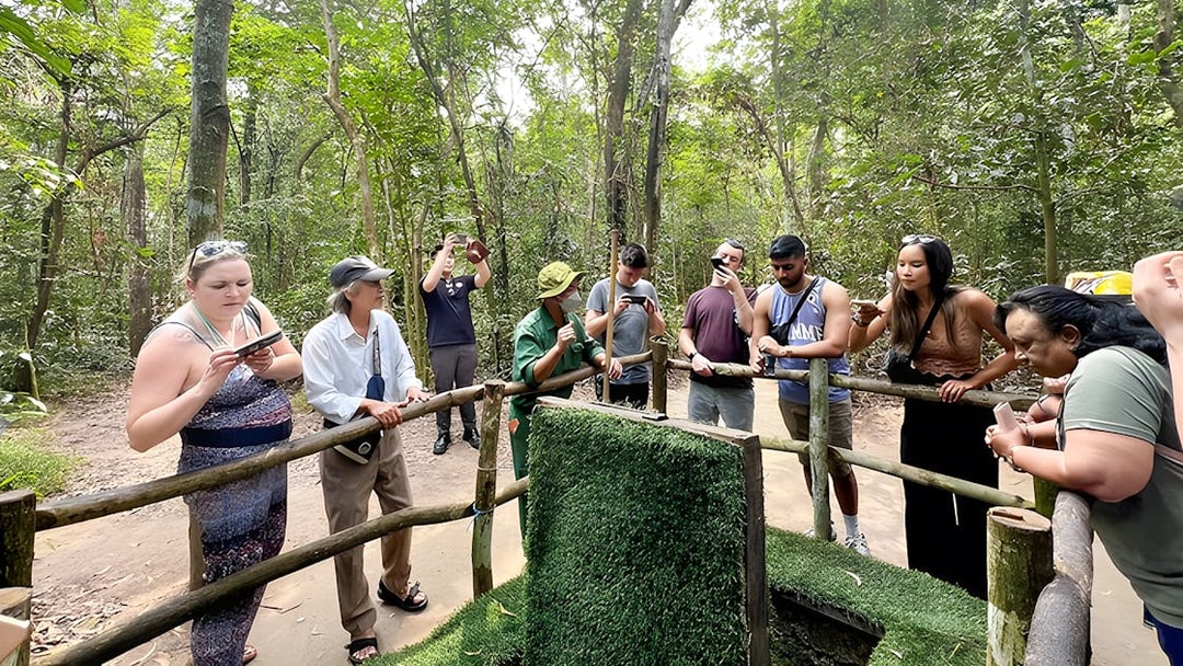 Visitors observing booby trap demonstration at Cu Chi Tunnels, Vietnam.