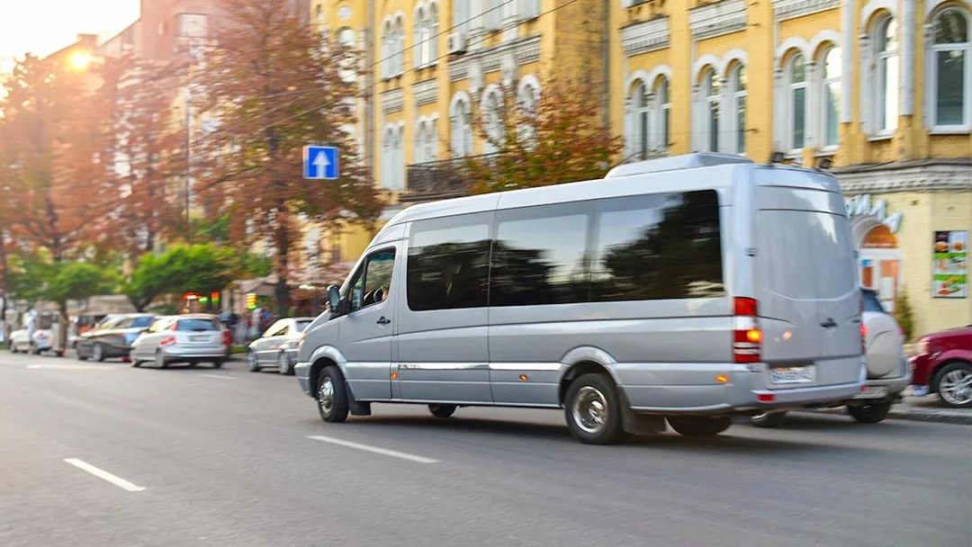 Minivan on city street for private transfer to Gatwick Airport.