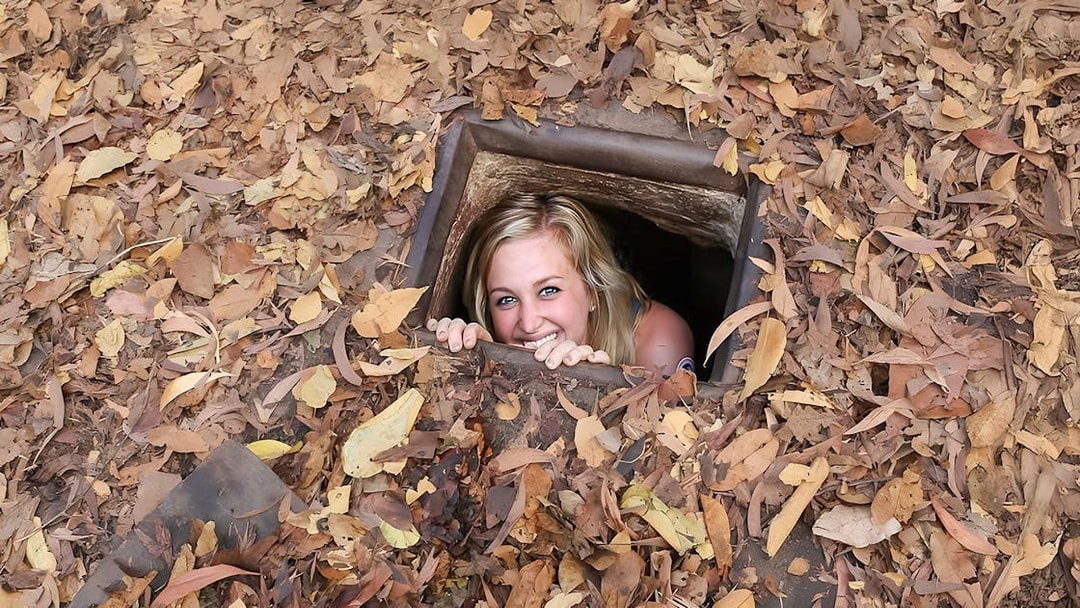 Woman emerging from Cu Chi tunnel in Vietnam.
