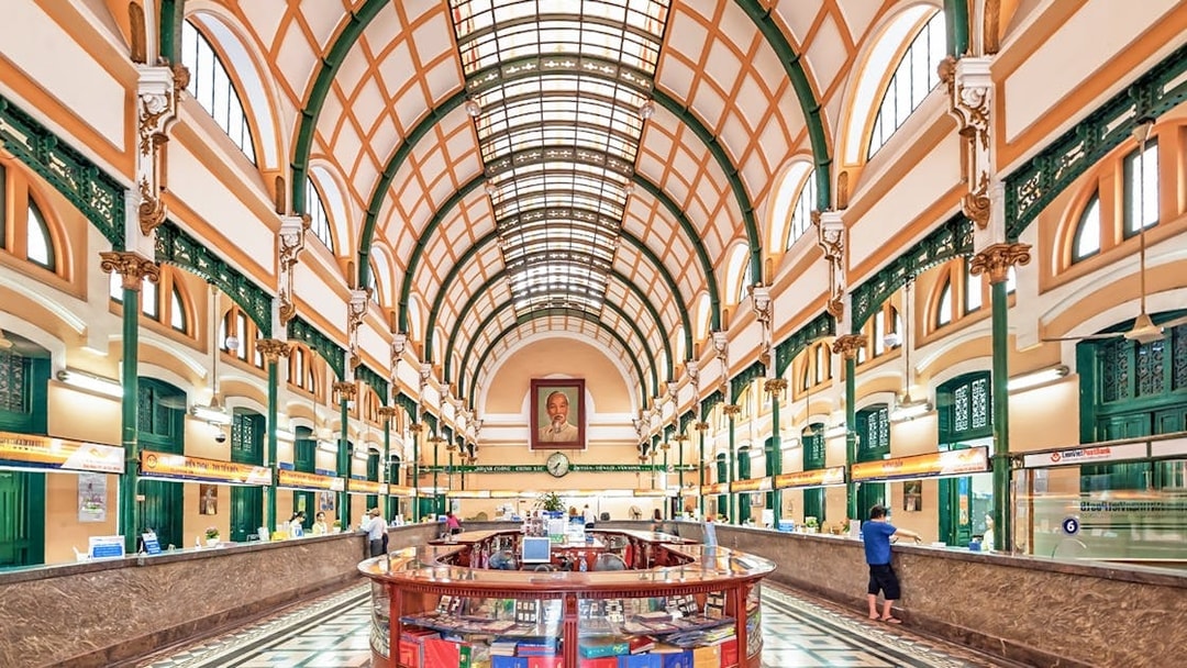 Saigon Central Post Office interior with arched ceiling and customer service counters.