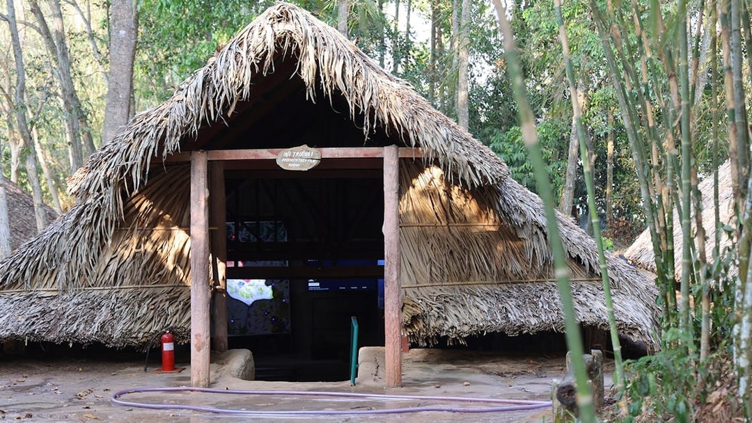 Hut room entrance at Cu Chi Tunnels surrounded by trees.