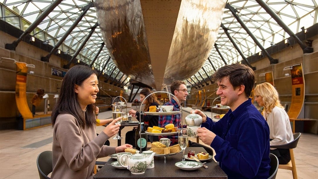 Guests enjoying afternoon tea under the Cutty Sark in London.