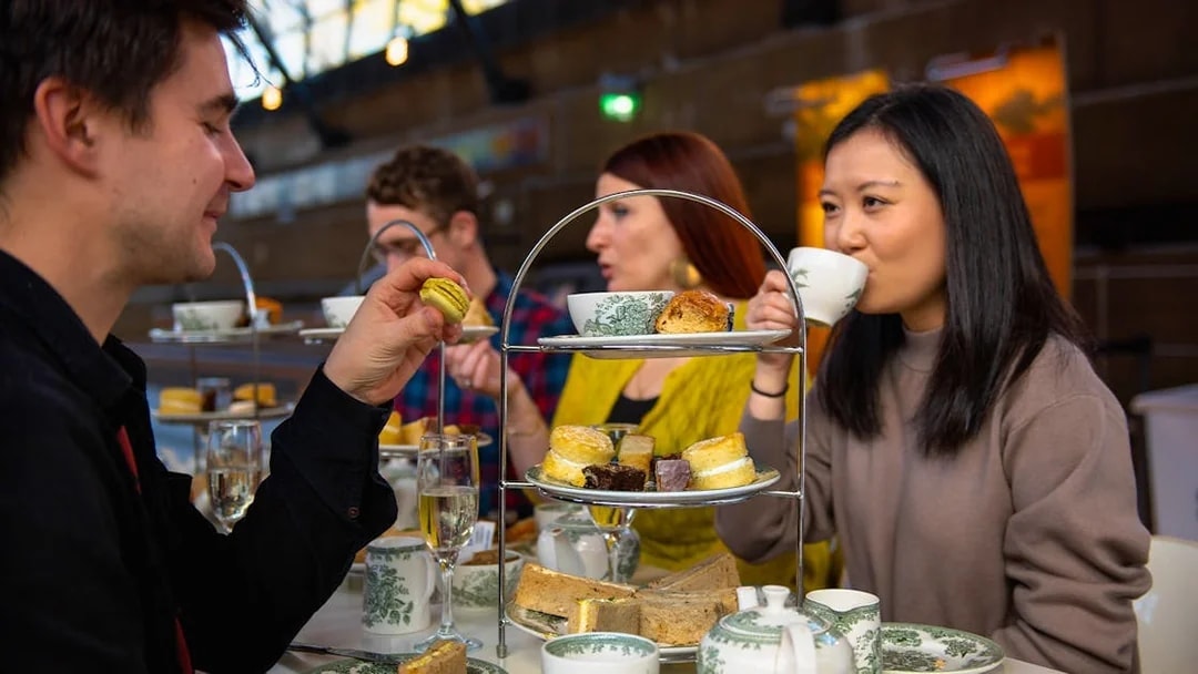 Guests enjoying afternoon tea at Cutty Sark with pastries and tea sets.