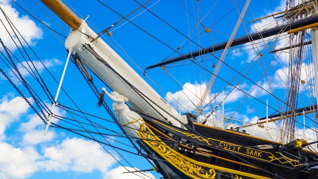 Cutty Sark ship's bow and figurehead against a blue sky in Greenwich.