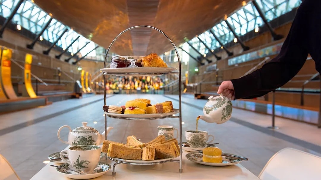 Afternoon tea setup with sandwiches and pastries at Cutty Sark, Greenwich.