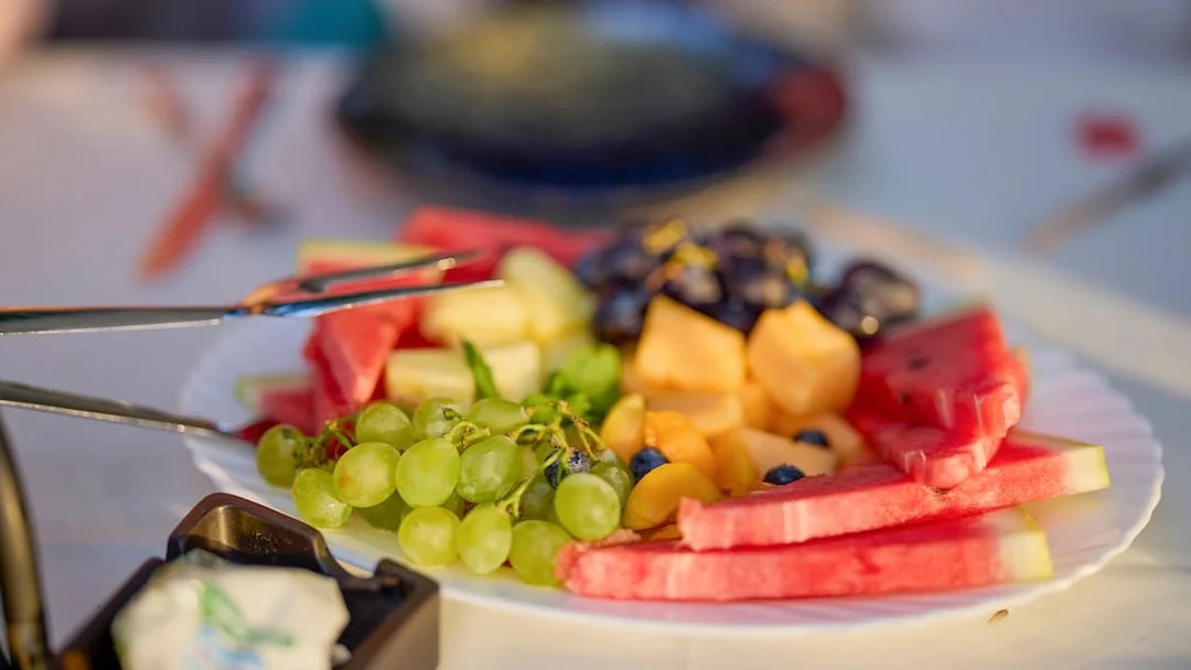 Plate of fresh fruits including watermelon, grapes, and melon on Langkawi day cruise lunch.