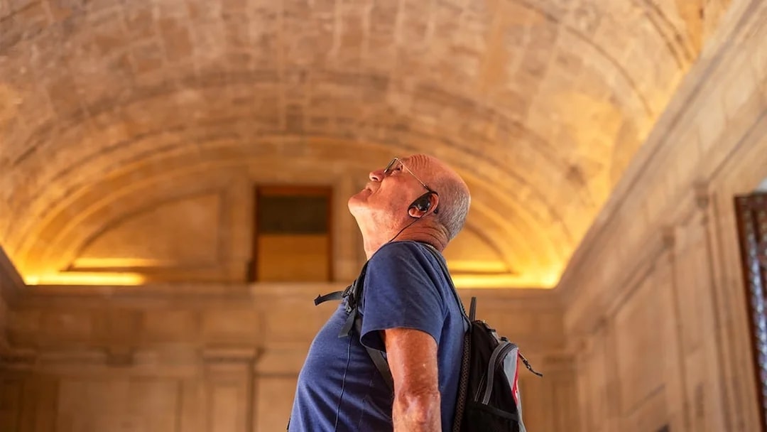 Man with audio guide admiring the Roman Pantheon interior.