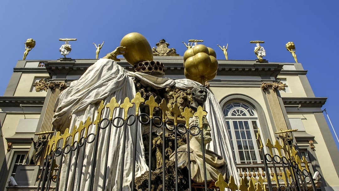 Sculpture at Dalí Theatre-Museum in Figueres, featuring surreal figures and golden elements.