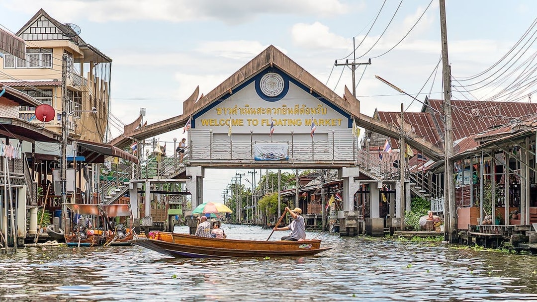 Damnoen Saduak Floating Market entrance with boats on the canal, Thailand.