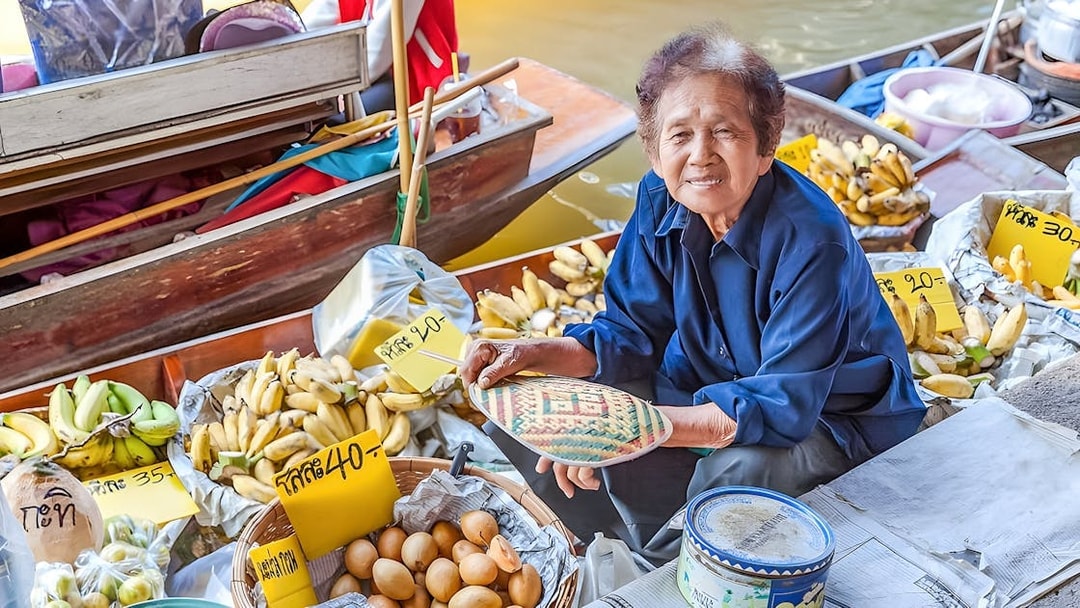 Vendor selling bananas and eggs at Damnoen Saduak Floating Market, Thailand.
