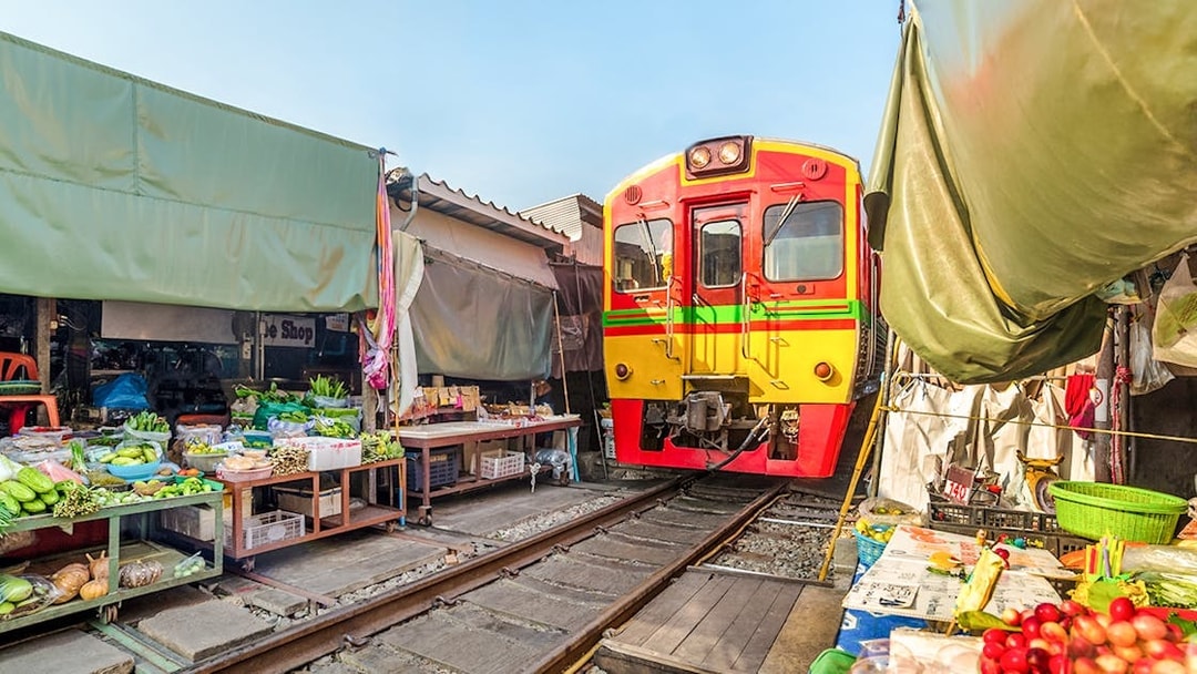 Train passing through Umbrella Fresh Market on the railroad track, Mae Klong Train Station, Bangkok.
