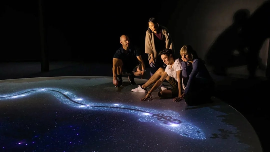 Group exploring star map at Dark Sky Indoor Cultural Astronomy Experience.