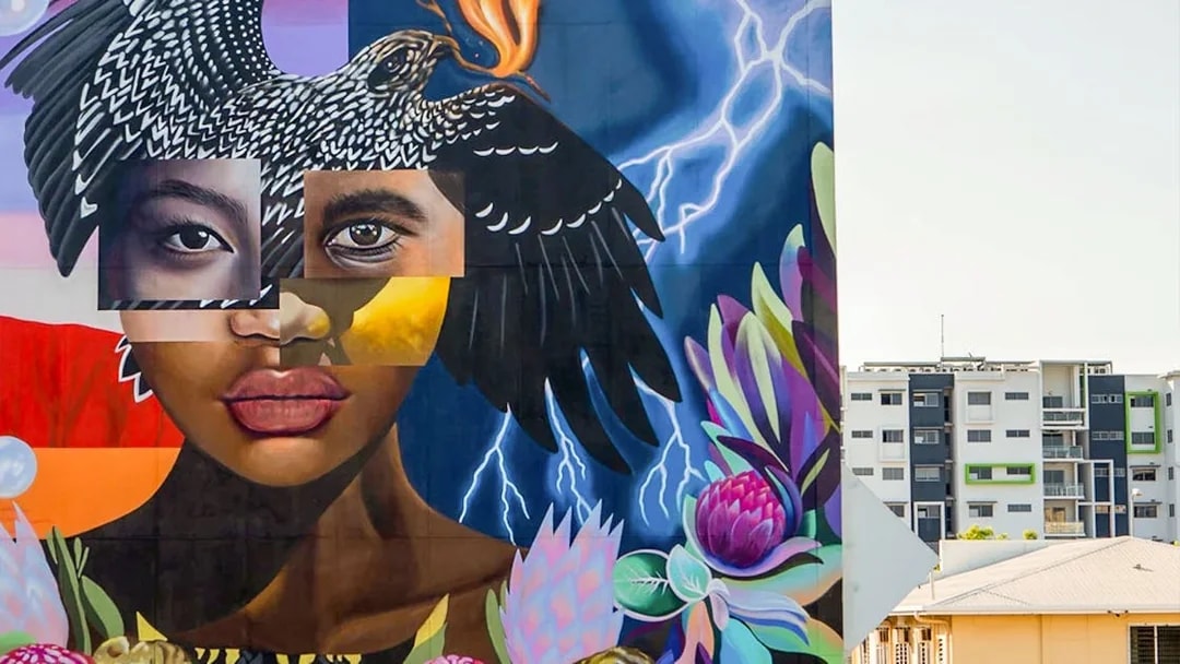 Colorful street art mural featuring a woman's face and bird, part of a 3.5-hour art tour.