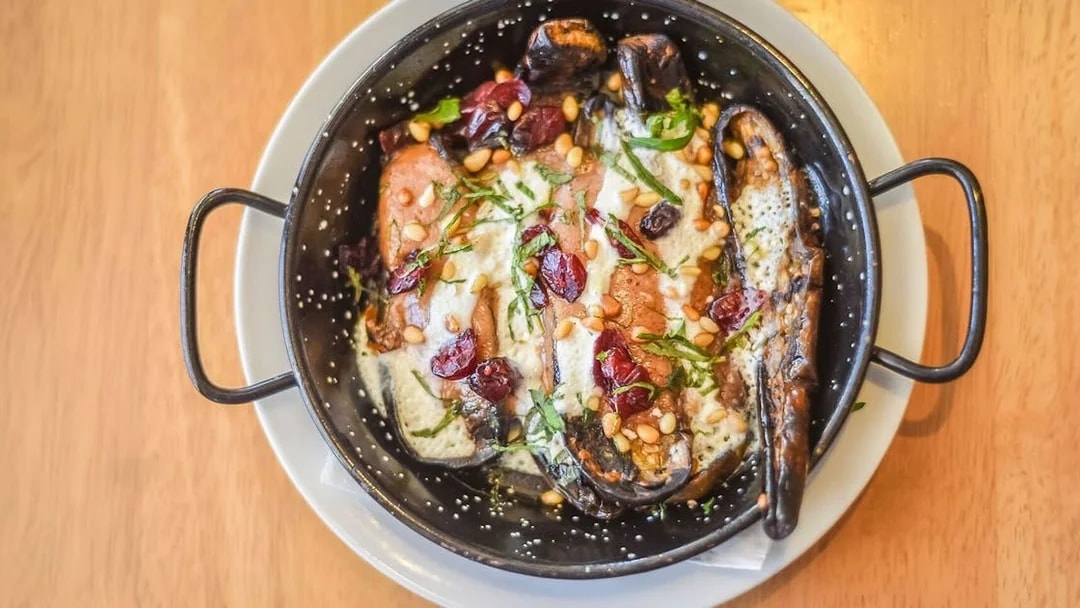 Gourmet dish with eggplant, pine nuts, and cranberries on a 3.5-hour art tour.