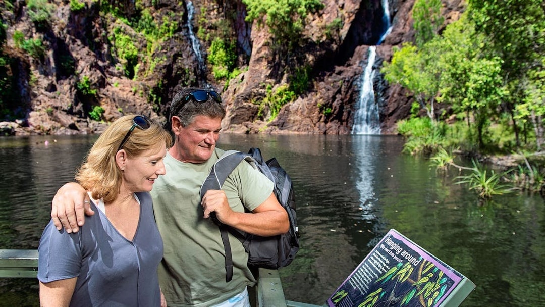 Couple reading sign at waterfall in Litchfield National Park, Darwin day tour.