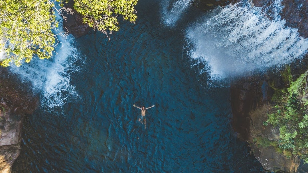 Swimming beneath waterfalls at Litchfield National Park, Australia.
