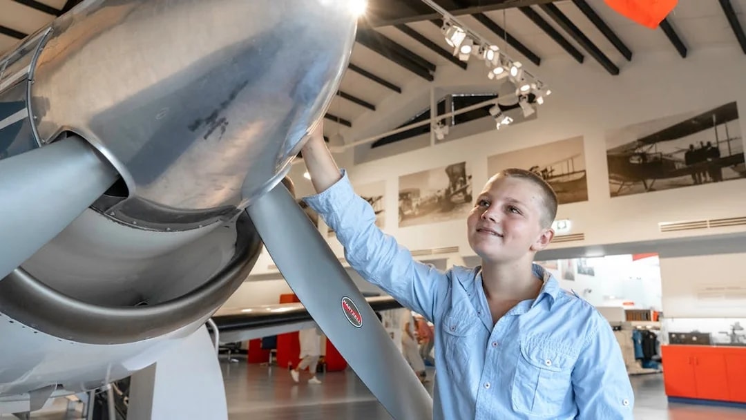 Young visitor exploring aircraft exhibit at Darwin Royal Flying Doctor Service museum.