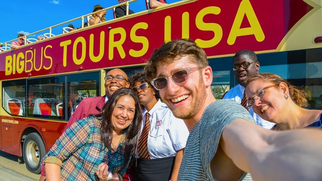 Group taking a selfie in front of a Big Bus Tours vehicle during Washington DC Hop-On-Hop-Off Tour.