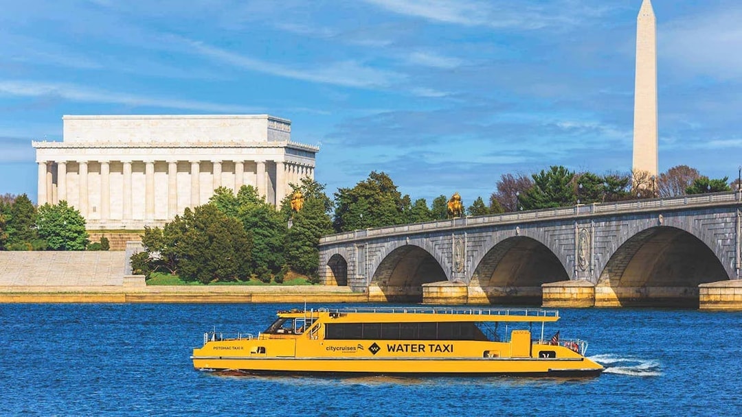 Yellow water taxi on Potomac River with Lincoln Memorial and Washington Monument in background.