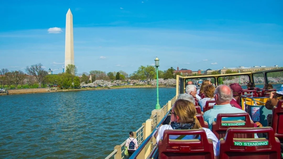 Tourists on open-top bus viewing Washington Monument, Washington DC.