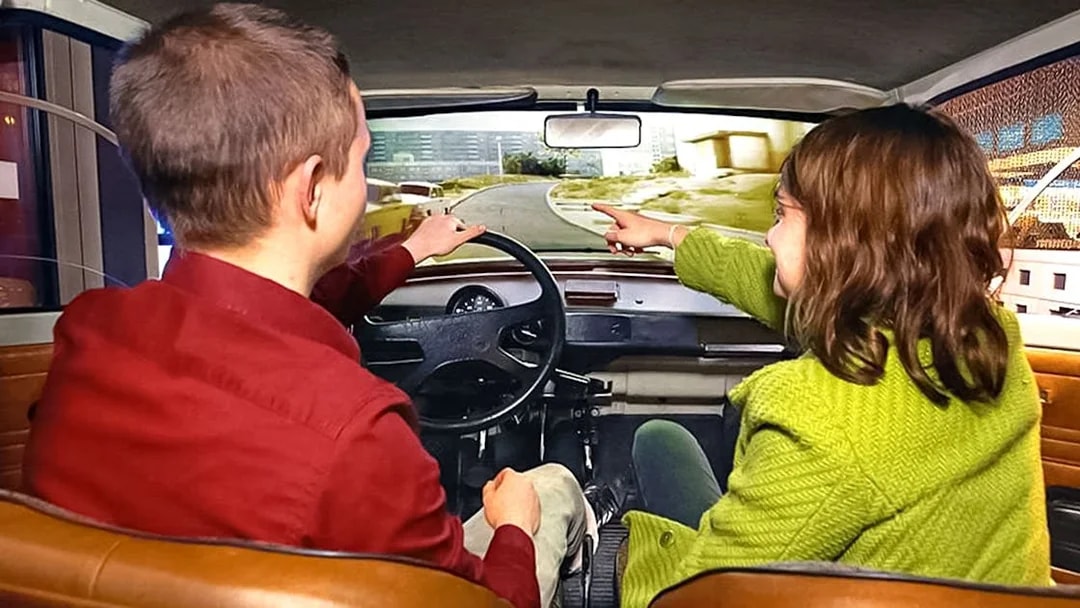 Visitors in a simulated car experience at DDR Museum Berlin.