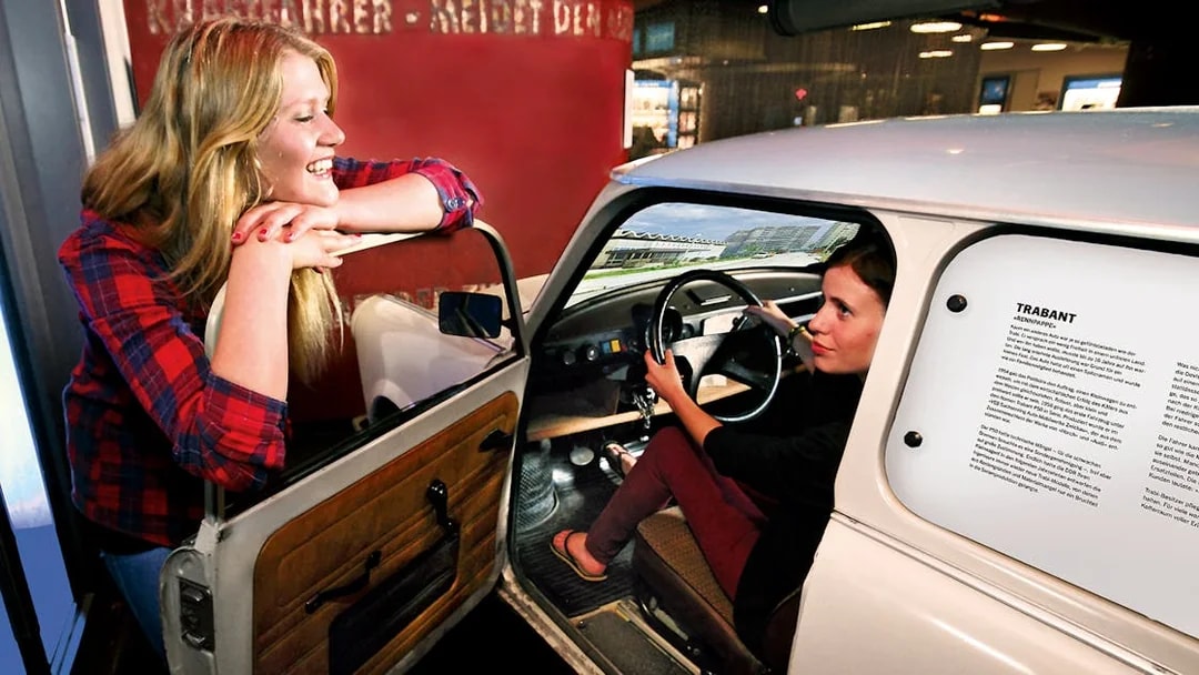 Person experiencing driving simulation in a Trabant at DDR Museum, Berlin.