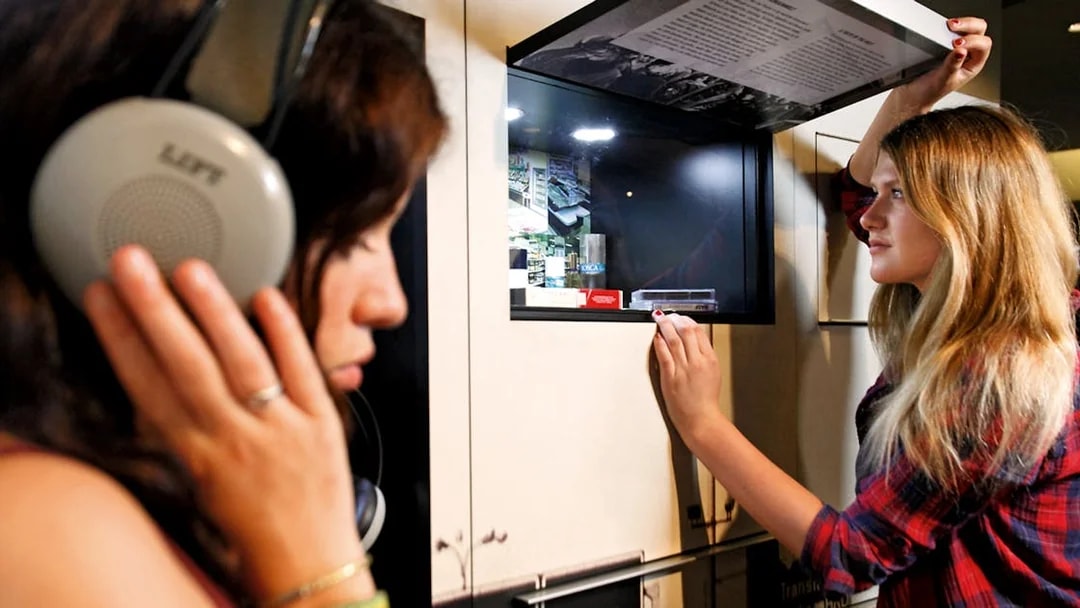 Visitors interacting with exhibits at DDR Museum Berlin.