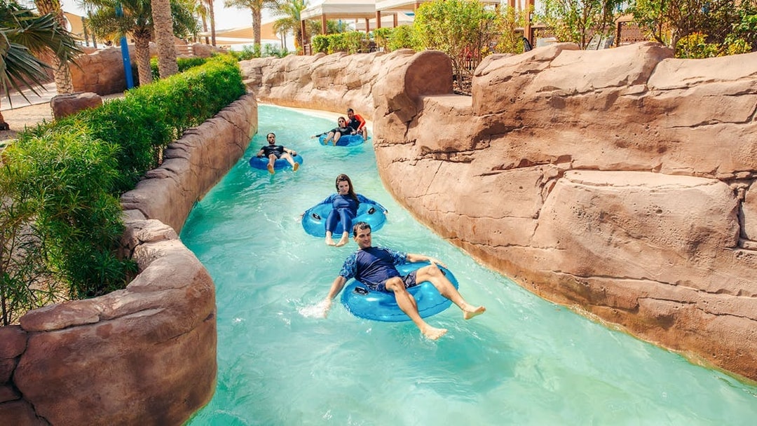 People enjoying a lazy river ride at a water park in Doha.