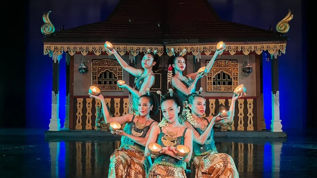 Performers holding lights on stage during the Devdan Show in Bali, showcasing cultural dance.
