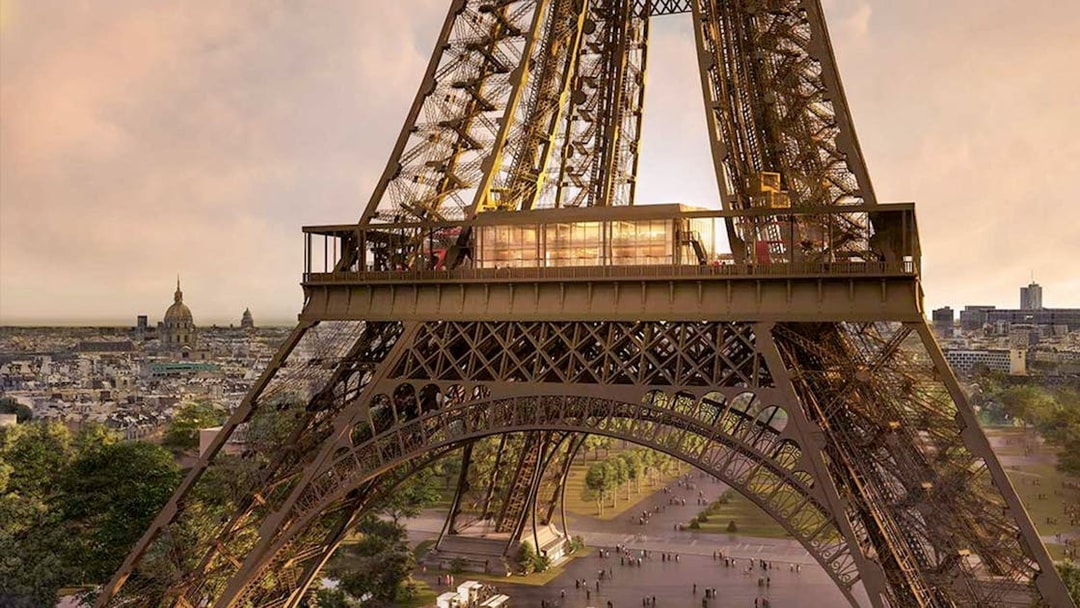 Eiffel Tower's Madame Brasserie exterior with Paris skyline in the background.
